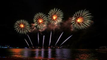 Amazing beautiful colorful fireworks display on celebration night, showing on the sea beach with multi color of reflection on water photo