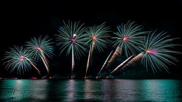 Amazing beautiful colorful fireworks display on celebration night, showing on the sea beach with multi color of reflection on water photo