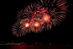 Amazing beautiful colorful fireworks display on celebration night, showing on the sea beach with multi color of reflection on water photo