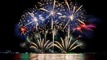 Amazing beautiful colorful fireworks display on celebration night, showing on the sea beach with multi color of reflection on water photo