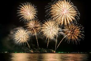 Amazing beautiful colorful fireworks display on celebration night, showing on the sea beach with multi color of reflection on water photo