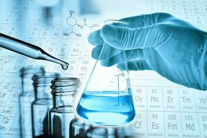 Flask in scientist hand with lab glassware background photo