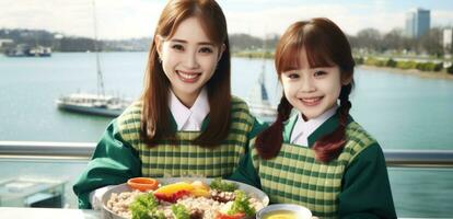 Two young asian girls, one with a green checkered shirt, holding a tray of food.. Generative AI photo