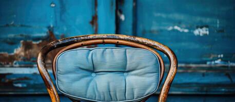 Close up of an aged chair featuring a blue cushion photo