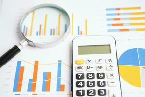 Magnifying glass on charts graphs paper. Financial development, Banking Account, Statistics, Investment Analytic research data economy. photo