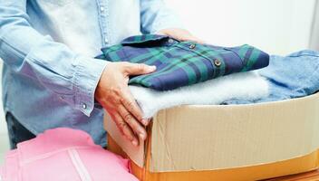 Clothes donations in cardboard box for volunteer. photo