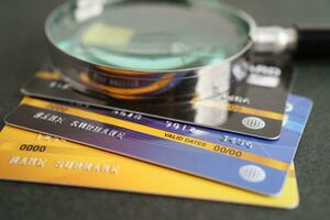 Credit card and magnifying glass for online shopping, security finance business concept. photo