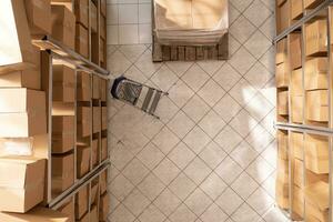 Empty storehouse full with metallic shelves and cardboard boxes, waiting for employee to come and work at customers orders. Storage room with nobody in it ready for packages delivery photo