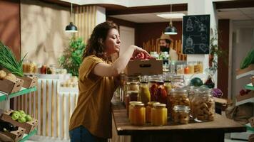 Client verifying apples in local bio food store are organic, feeling dopamine rush while smelling their nice aroma, Woman in zero waste shop checking fruits are chemicals free before making purchase video