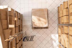 Empty stockroom full with metallic shelves and carton boxes, waiting for workers to come and work at clients orders. Storage room with nobody in it ready for packages delivery. Warehouse concept photo