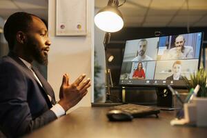 Entrepreneur discussing investment graph with remote team during online videocall meeting conference, working overtime at company strategy in startup office. Business management concept photo