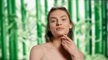 Luminous radiant woman posing with confidence, creating self love skincare ad campaign in studio. Beautiful smiling girl feeling happy over bamboo trees background, self acceptance. photo