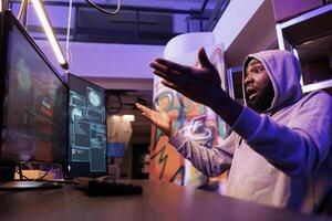 Angry hacker failing to pass computer security system while hacking online server. African american criminal getting access denied notification while breaking into website photo