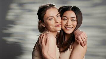 Cheerful beauty models posing on camera for campaign, advertising self acceptance and skincare products. Happy friends with different skintones promoting diversity and body confidence. photo