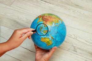 hand looks at the globe with a magnifying glass Indonesian Islands photo