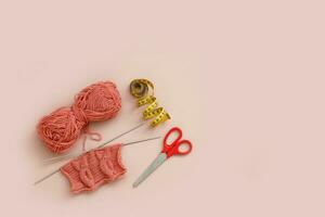 knitting and a skein of thread, scissors and a measuring tape with copy space photo