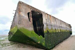 the remains of a concrete boat on the beach photo