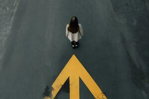 Woman near yellow arrow asphalt top view. Generate ai photo