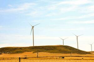 wind turbines on a hill in the middle of a field photo