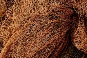 a close up of a pile of brown fishing nets photo