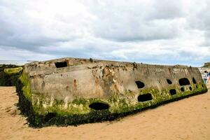 the remains of a concrete boat on the beach photo