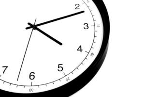 Part of analogue plain wall clock on white wall background. Four o'clock twelve minutes. Close up with copy space, timing, time management, opening hours time, school concept and lunch time. photo