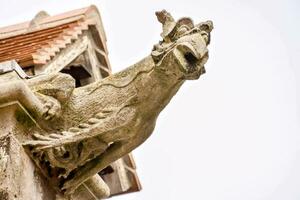 gargoyle on the roof of a building photo