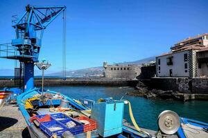 a fishing boat docked in the harbor with blue water photo