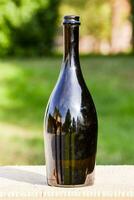 a black bottle sitting on a wooden table photo