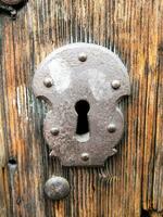 a close up of a wooden door with a keyhole photo