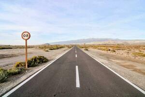 an empty road in the middle of a desert photo