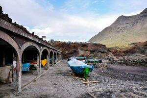 boats are parked on the beach near a mountain photo