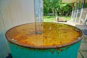 a rusty metal barrel with a yellow substance on it photo