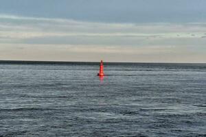 a red buoy in the middle of the ocean photo