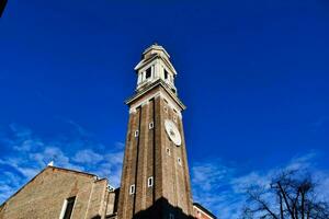 a tall clock tower with a blue sky in the background photo