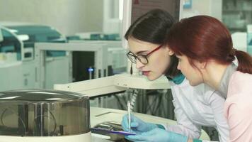 Two female biologists making notes while conducting experiments video