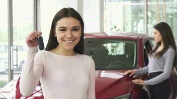 Cheerful young woman showing thumbs up holding car keys video
