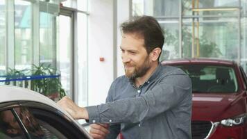 Mature happy handsome man posing with his new automobile video