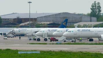 almatië, Kazachstan mei 4, 2019 - rij van passagier vlak van lucht astana Aan de vliegveld parkeren. luchthaven met vliegtuigen aangemeerd voor onderhoud en bezig met laden. vliegtuig vloot. toerisme en reizen concept video