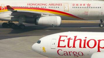 HONG KONG NOVEMBER 10, 2019 - Airbus A330 of Hong Kong Airlines taxiing at Hong Kong Airport, side view. Cargo Boeing 777 of Ethiopian Airlines. Aircraft on taxiway. video