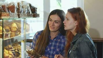 Female friends choosing cookies at the bakery shop video