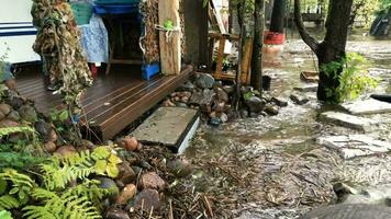 flood, the river has overflowed its banks, the water carries everything that can float, a man with a pole pushes from the threshold, floating boxes and garbage,  time lapse video