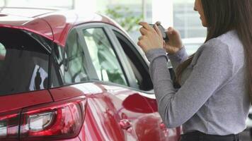 Cropped shot of a woman taking photos of her new car video