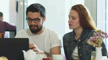 adorável casal usando aparelhos juntos enquanto tendo café da manhã às a café fazer compras video