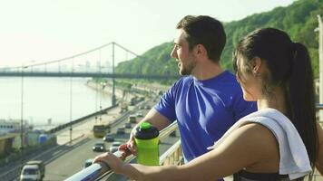 Lovely sports couple relaxing after morning workout in an urban city video