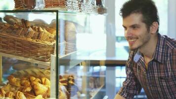 gut aussehend Mann wählen Nachspeisen von das Vitrine beim das Bäckerei video