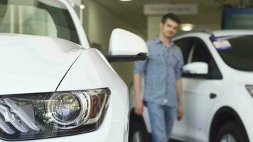 masculino cliente sonriente mirando a el nuevo auto a el concesión video