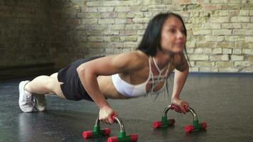 atlético mujer haciendo Lagartijas a el gimnasio video