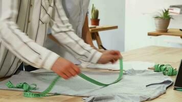 Fashion designers measuring t-shirt, working at their workspace video