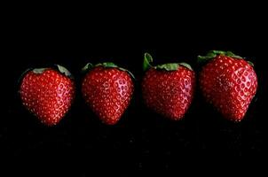 Strawberries isolated on black background photo